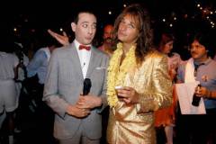 Comedian & actor Paul Reubens (1952 - 2023) (left), as his character Pee-Wee Herman, and singer David Lee Roth pose together at the premiere of the movie 'Pee-Wee's Big Adventure,' at Gruman's Chinese Theater, Los Angeles, August 1, 1985. (Photo by Richard E. Aaron/Redferns)